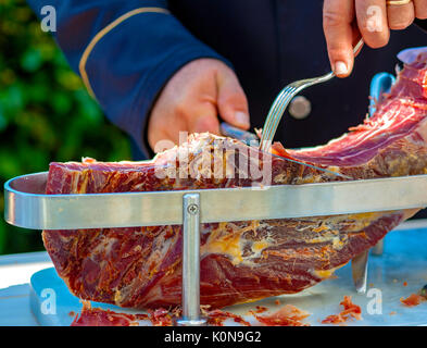 Waiter est slicing raw ham,italien Banque D'Images