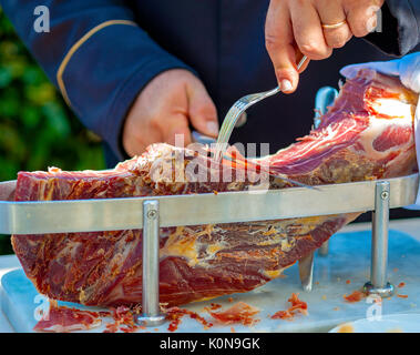 Waiter est slicing raw ham,italien Banque D'Images