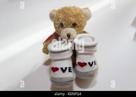 Baby Girl - rouge et blanc avec des chaussettes sur fond blanc. Banque D'Images