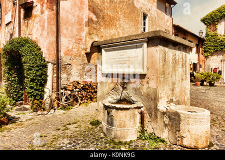 La fontaine de l'eau potable dans la Piazza della Rocca - village médiéval d'Ostia Antica - Rome Banque D'Images