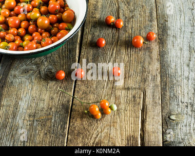 Les tomates cerise lavées dans un bol en bois de IF Metall sur table patiné Banque D'Images