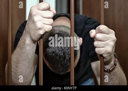 Abstract. Les mains du prisonnier sur un treillis en acier de près. L'homme en prison, menottes. Assassin, un meurtrier derrière les barreaux. Banque D'Images