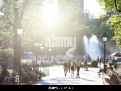 L'anonymat des foules de gens avec la lumière du soleil qui brillait à travers les arbres du parc de Washington Square à New York City NYC Banque D'Images