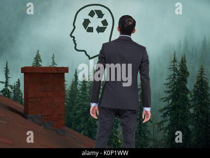 Digital composite de tête avec l'icône durable recyclables et businessman standing on Roof avec cheminée et forêt brumeuse Banque D'Images