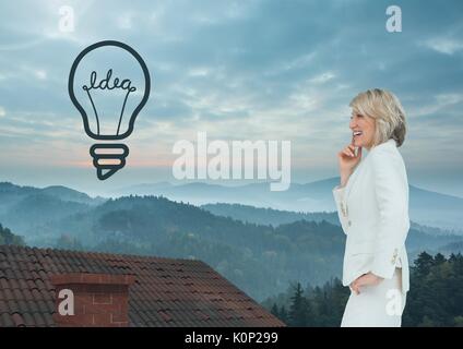 Digital composite de l'icône de l'ampoule et Businesswoman standing on Roof avec cheminée et misty landscape Banque D'Images