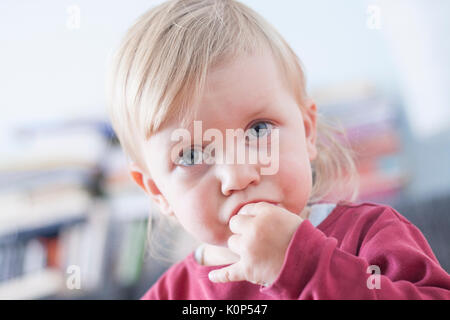 Petite blonde aux yeux bleus baby girl eating Gummy Bear, la vaseline. Banque D'Images