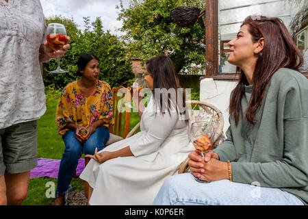Les membres de la famille de discuter à un barbecue familial, Sussex, UK Banque D'Images