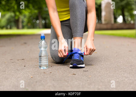 Jeune femme attachant lacets de chaussures de course avant l'entraînement. Concept de vie sain Banque D'Images