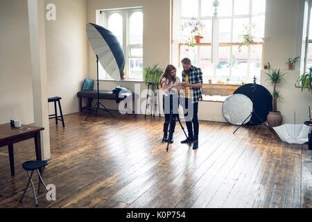 Au cours photographes digital tablet while standing in studio Banque D'Images
