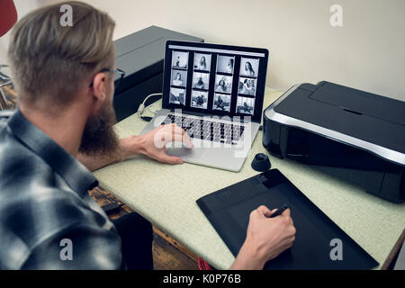 Photographe de l'écriture sur tablette graphique while using laptop Banque D'Images