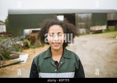 Portrait of happy woman standing near barn Banque D'Images