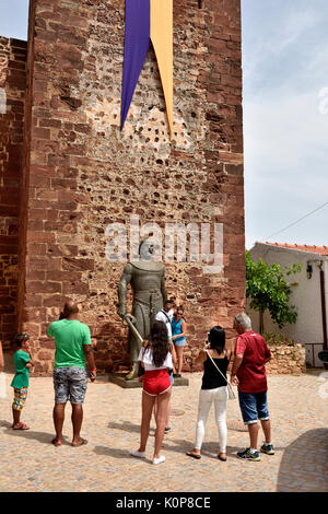 Les touristes à la recherche de la statue du roi Sancho I de Portugal à l'entrée de château de Silves mauresque Banque D'Images