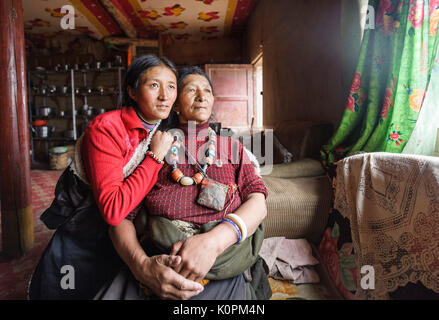 Un tibétain mère et fille dans sa maison traditionnelle portant les accessoires traditionnels de sa tribu, plateau tibétain Banque D'Images