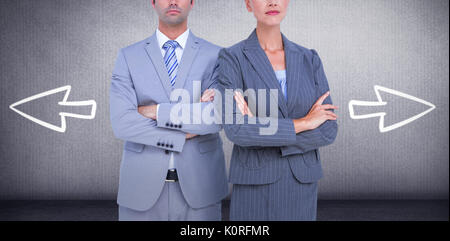 Les gens d'affaires with arms crossed looking at camera contre salle grise Banque D'Images