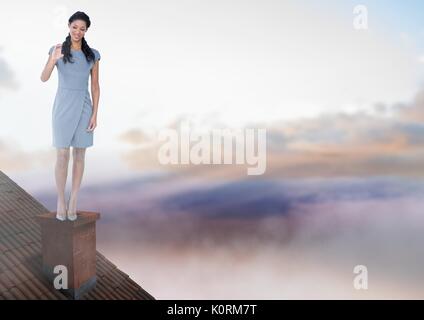 Digital composite of Businesswoman standing on Roof avec cheminée et ciel coloré Banque D'Images