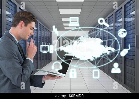 Digital composite of business man holding un ordinateur et des graphiques en salle serveur Banque D'Images