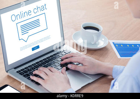 Bulle avec chat en ligne texte contre close-up of businesswoman using laptop Banque D'Images