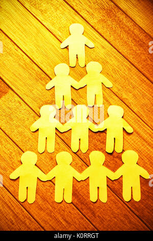 High angle view of paper cut out figures formant pyramide humaine sur la table Banque D'Images