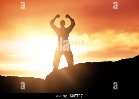 Fighter posant après la victoire contre vue panoramique sur mer contre sky pendant le coucher du soleil Banque D'Images