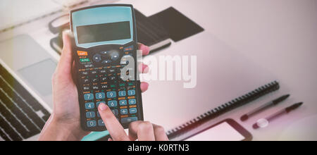 Mains de businesswoman using calculator contre high angle view de documents et agenda Banque D'Images