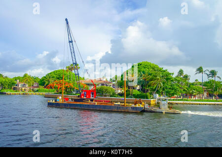 FORT LAUDERDALE, USA - 11 juillet 2017 : construction flottante avec une machine rouge plus de naviguer dans la promenade Riverwalk, les tours d'habitation en copropriété derrière à Fort Lauderdale, Floride Banque D'Images
