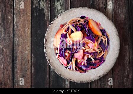 Plat de pâtes d'automne avec les pommes, le chou mauve et bacon, overhead view sur bois rustique Banque D'Images