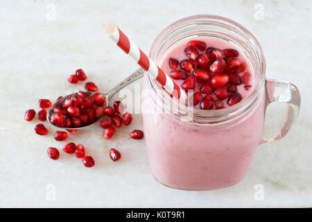 Smoothie framboise grenade dans un pot Mason sur verre marbre blanc Banque D'Images