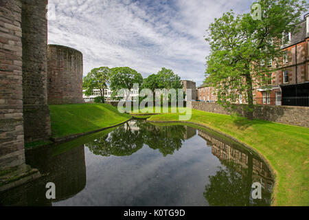 Voir l'historique, du château, de la ville de Rothesay avec des bâtiments et remparts du château reflète dans l'eau des douves sous ciel bleu sur l'île de Bute, Ecosse Banque D'Images