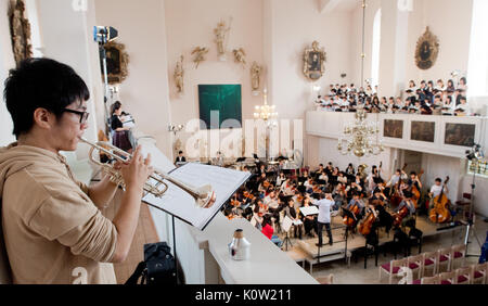 Le choeur et orchestre de l'Université d'Elisabeth Hiroshima Répéter pour un concert en avant de la basse-saxonne 31 jours de musique dans l'Église Neustadter à Hanovre, Allemagne, 24 août 2017. Le concert spécial 'starless night' pour choeur, orchestre, soprano, mezzo-soprano et deux narrateurs est composé de neuf mouvements par laquelle la bombe sur Hiroshima et Dresde sont décrites. Photo : Julian Stratenschulte/dpa Banque D'Images