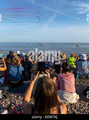 La foule envahit la plage lors d'une soirée glorieuse pour l'exposition des flèches rouges, qui signale le début de la régate de Sidmouth. Banque D'Images