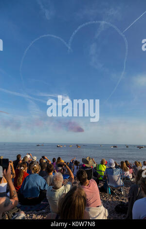 La foule envahit la plage lors d'une soirée glorieuse pour l'exposition des flèches rouges, qui signale le début de la régate de Sidmouth. Banque D'Images