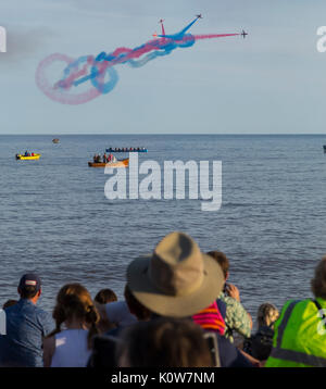 La foule envahit la plage lors d'une soirée glorieuse pour l'exposition des flèches rouges, qui signale le début de la régate de Sidmouth. Banque D'Images