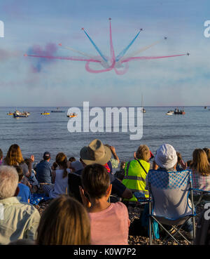 La foule envahit la plage lors d'une soirée glorieuse pour l'exposition des flèches rouges, qui signale le début de la régate de Sidmouth. Banque D'Images