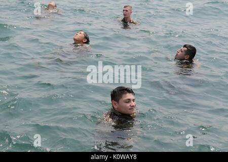 170818-A-RW053-132 Des soldats de la 371e brigade de maintien en puissance, 411e Détachement de transport et ASG-Koweït dans le processus d'enlever leur pantalon dans l'eau pour être utilisé pour flotter au cours de la formation d'Épreuvage se noient dans la région du Golfe le 17 août 2017. (U.S. Photo de l'armée par le Sgt. 1re classe Charles Highland) Banque D'Images