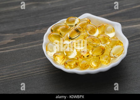 Close-up de capsules d'Oméga-3 huile de poisson dans un bol blanc sous la forme d'un shell Banque D'Images