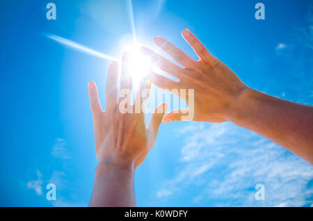 Deux palmiers couvrir du soleil. Vue à la première personne du ciel. Soleil brille à travers les doigts Banque D'Images