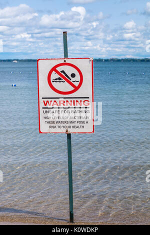 Signe de nageurs d'avertissement affiché les niveaux de bactéries dangereuses dans l'eau à la plage. Banque D'Images