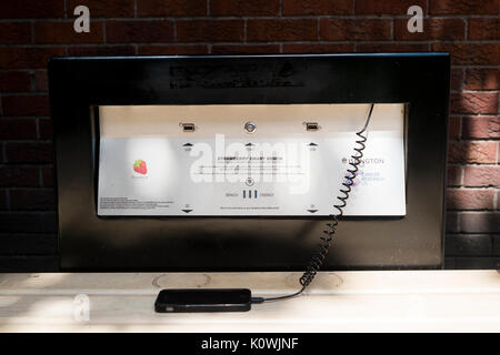 Une fraise à alimentation solaire banc smart téléphones et tablettes sous tension et proposant une connexion Wi-Fi gratuite l'objet d'une période d'essai à l'arrêt de bus Old Street, Londres, Banque D'Images