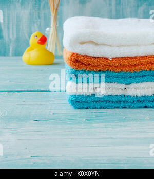 Pile de serviettes colorées et baignoire canard sur la table, des accessoires pour la salle de bains Banque D'Images