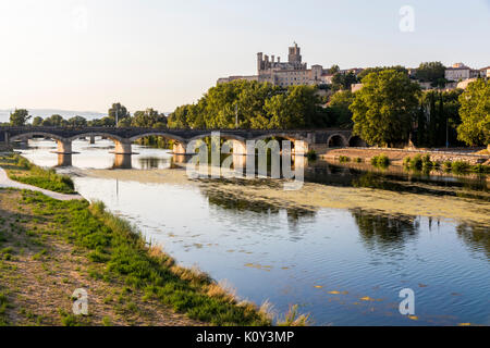 Vues au coucher du soleil de la ville de Béziers, d'arbres et l'un de ses ponts reflétée sur la rivière Orb, et le 13e siècle Cathédrale de Saint Banque D'Images