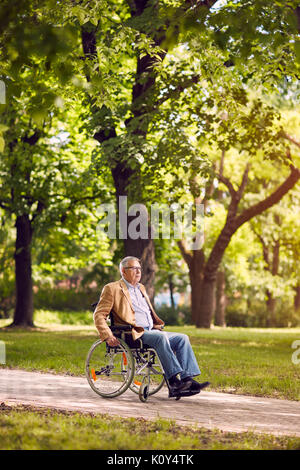 Vieil homme handicapé sur fauteuil roulant dans le parc Banque D'Images