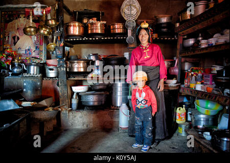 Femme tibétaine et son fils dans leur Kitlchen d'or. Plateau tibétain Banque D'Images