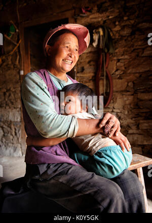 La mère et l'enfant tibétain traditionnel à leur accueil dans un village Pudong, Gyarong, Kham, province du plateau tibétain Banque D'Images