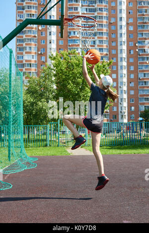 Joueur de basket-ball fille lance la balle dans le panier Banque D'Images