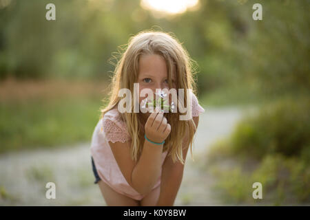 Little girl with bouquet dans la forêt Banque D'Images