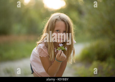 Little girl with bouquet dans la forêt Banque D'Images