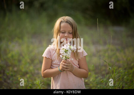 Little girl with bouquet dans la forêt Banque D'Images