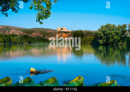 Certains des kayaks à la rivière Ebre Miravet, en passant par l'Espagne, en soulignant son château des Templiers dans le haut de la colline Banque D'Images