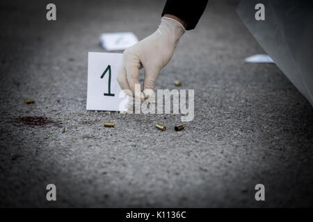 La scène du crime, le meurtre, l'enquête, les manches des coups de servir de preuve, l'enquête est terminée, l'expert prend la capsule des forceps et placés dans Banque D'Images