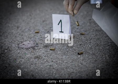 La scène du crime, le meurtre, l'enquête, les manches des coups de servir de preuve, l'enquête est terminée, l'expert prend la capsule des forceps et placés dans Banque D'Images